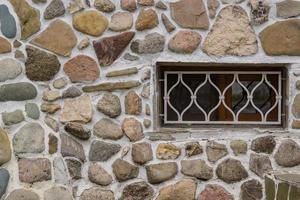 old stone wall and white lattice on a window. photo