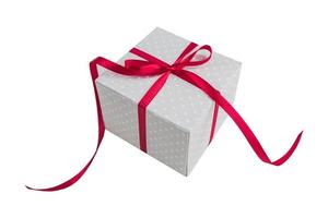 Beige polka dot gift box with red ribbon bow isolated on white background. photo