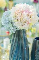 close up of blue glossy vase with hydrangea flovers. Interior decoration. photo