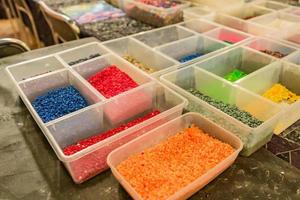 plastic boxes with multicolored small gravel stones for decoration at workshop photo