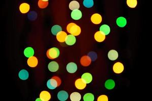 luces borrosas abstractas en el fondo en colores azul, verde y naranja. - concepto de celebración de navidad foto