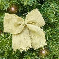 Canvas bow and led garland on fir tree. Christmas and new year background for greeteng card. photo