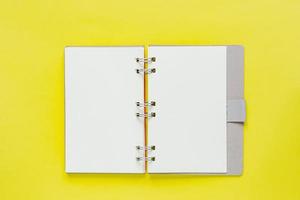 Clean note book for goals and resolutions in recycling paper cover. mockup for your design. Spiral note book on yellow background. photo