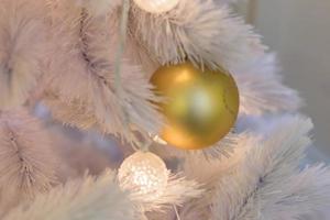 Christmas and New Year holidays background.  White Christmas tree decorated with white and gold balls. Celebration concept photo