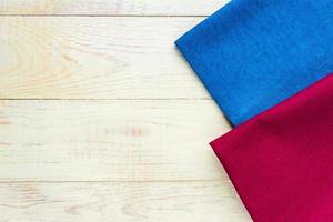 Top view of cloth napkins of blue and burgundy colors on rustic white background. Copy space for text photo
