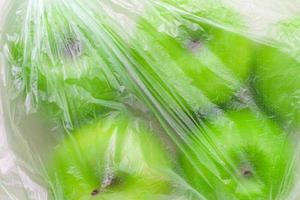 Fresh green apples in plastic bag closeup. environmental concept of non-ecological use of plastic photo