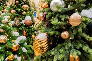 close up of christmas trees decorated with sparkling balls and garland with lights on. Festive background with copy space for your projects photo