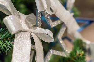 fondo de vacaciones de navidad y año nuevo. árbol de navidad decorado con lazo plateado y estrella azul. concepto de celebración foto