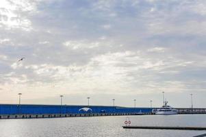 Large white yacht parked on the background of dock photo