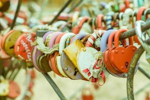 Plenty of multicolored love padlocks on metal railing of the bridge. selective focus, toned. photo