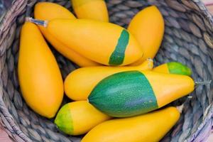 Top view of small decorative pumpkins Kleine Birne Bicolor in whicker basket. photo