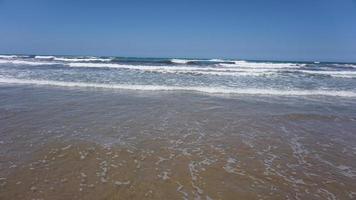 suave ola de océano azul en la playa de arena. foto