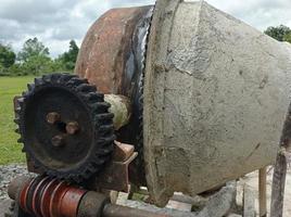 a concrete mixer installed on a construction site next to a pile of sand and gravel. photo