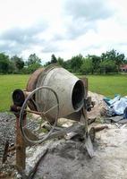 a concrete mixer installed on a construction site next to a pile of sand and gravel. photo