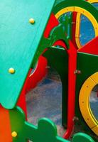 An element of a children's swing. rope. An outdoor colorful playground next to the house. A summer day. Children's playground with rubber floor covering. photo