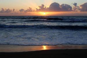 el sol se pone por debajo del horizonte en el mar mediterráneo en el norte de israel. foto