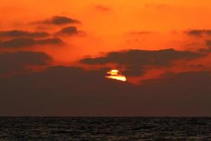 el sol se pone por debajo del horizonte en el mar mediterráneo en el norte de israel. foto