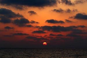 el sol se pone por debajo del horizonte en el mar mediterráneo en el norte de israel. foto