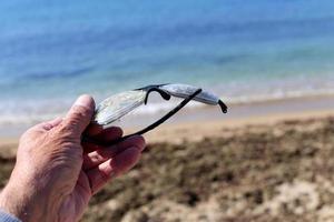 Old glasses are lying in the city park on the seashore. photo