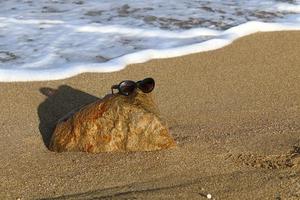 las gafas viejas yacen en el parque de la ciudad a orillas del mar. foto