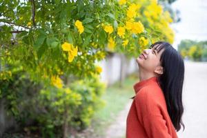 retrato joven con flores amarillas, chica asiática. foto