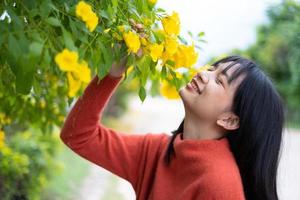 retrato joven con flores amarillas, chica asiática. foto