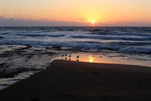 el sol se pone por debajo del horizonte en el mar mediterráneo en el norte de israel. foto