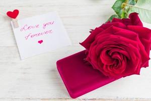 jewelry gift box and bautiful red rose on wooden background. photo