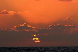 The sun sets below the horizon on the Mediterranean Sea in northern Israel. photo