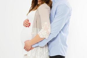 retrato recortado de una hermosa mujer embarazada y su apuesto esposo abrazando la barriga.concepto de amor. evento feliz,nacimiento de un niño,pareja foto