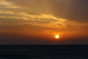 The sun sets below the horizon on the Mediterranean Sea in northern Israel. photo