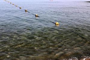 A rope with floats to secure a safe swimming area on the beach. photo