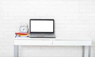 Education accessories on the table near brick wall. Empty computer and mobile screen with place for text. photo