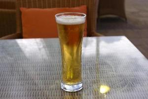 On the table in the restaurant a glass of fresh and cold beer. photo