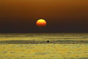 el sol se pone por debajo del horizonte en el mar mediterráneo en el norte de israel. foto