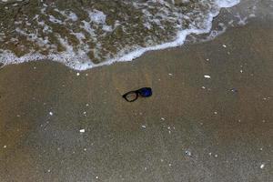 Old glasses are lying in the city park on the seashore. photo