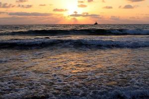 el sol se pone por debajo del horizonte en el mar mediterráneo en el norte de israel. foto