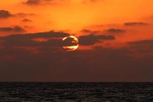 el sol se pone por debajo del horizonte en el mar mediterráneo en el norte de israel. foto