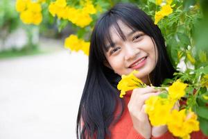 Portrait young girl with yellow flowers, Asian girl. photo