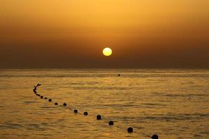 el sol se pone por debajo del horizonte en el mar mediterráneo en el norte de israel. foto