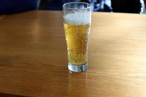 On the table in the restaurant a glass of fresh and cold beer. photo