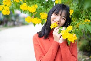 retrato joven con flores amarillas, chica asiática. foto