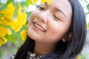 retrato joven con flores amarillas, chica asiática. foto