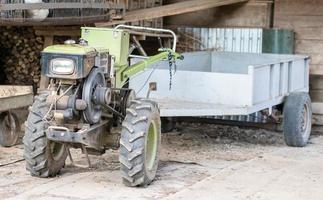 motocultor diésel pesado típico con remolque. equipos de transporte agrícola del campo. equipo agrícola portátil, minitractor ambulante. el sistema de arranque es mecanico y manual. foto