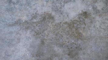 The old cement wall was weathered, the surface was scratched, the surface was scratched and damaged. For a mysterious retro-conservative background. photo