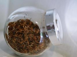 Dried tea leaves are well kept in a jar. photo