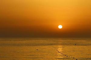 el sol se pone por debajo del horizonte en el mar mediterráneo en el norte de israel. foto