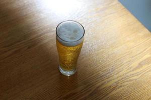 en la mesa del restaurante un vaso de cerveza fresca y fría. foto