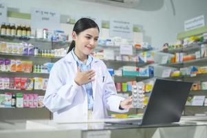 una farmacéutica que asesora a una clienta a través de una videollamada en una farmacia moderna. foto