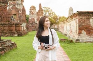 young beautiful woman traveling and taking photo at thai historical Park, Holidays and cultural tourism concept.